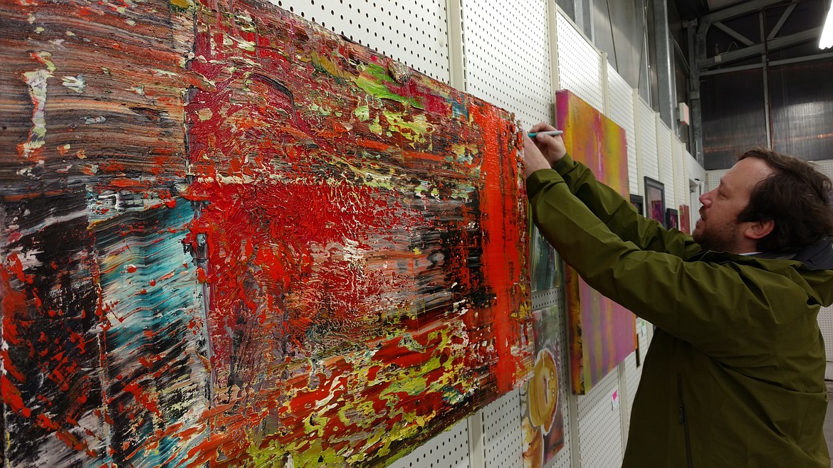 Jimmy Magnuson finishes labeling his works Saturday night during the grand opening of his first solo show. He works mainly in acrylic and oil, but also creates with pastels and nail polish. (DEVIN WEEKS/Press)