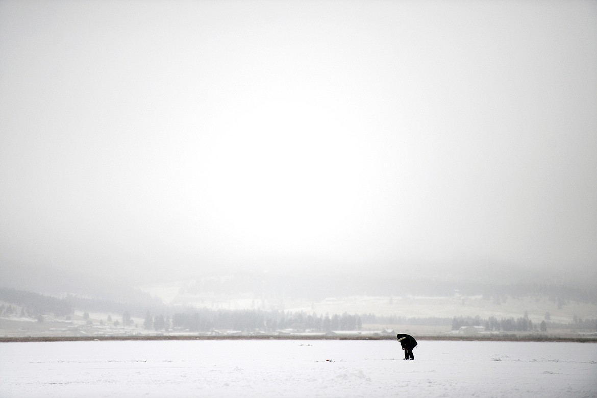 A fisherman pulls in a fish during the Sunriser Lions ice fishing derby at Smith Lake on Saturday. (Casey Kreider/Daily Inter Lake)