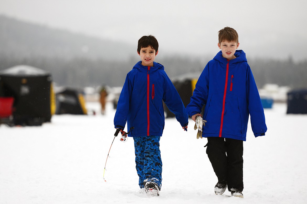 Kainoa Cecil, 7, left, and Tyler Price, 8, bring in a pike to be measured at the Sunriser Lions ice fishing derby at Smith Lake on Saturday. (Casey Kreider/Daily Inter Lake)