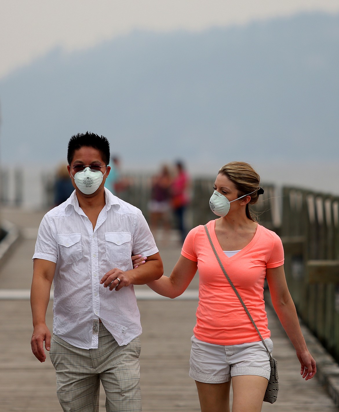 Fong and Stephenie Lee take a walk along The Coeur d'Alene Resort floating boardwalk in August this last year. Smoke from wildfires in Idaho, Canada, and Washington filled the air for much of the summer, especially August when air quality levels reached the &quot;hazardous&quot; mark. (LOREN BENOIT/Press File)