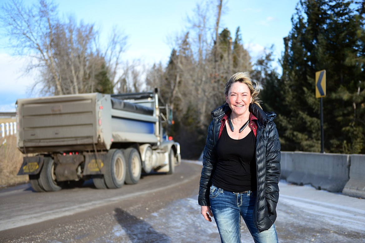 Debbie Street stands along a sharp bend in the road near her home on Rose Crossing. Completion of Rose Crossing has created a traffic hazard in the rural neighborhood. (Casey Kreider/Daily Inter Lake)