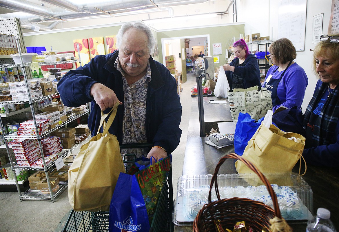 Gene Clemens, of Post Falls, places grocery bags into his cart after shopping at The Post Falls Food Bank. (LOREN BENOIT/Press)