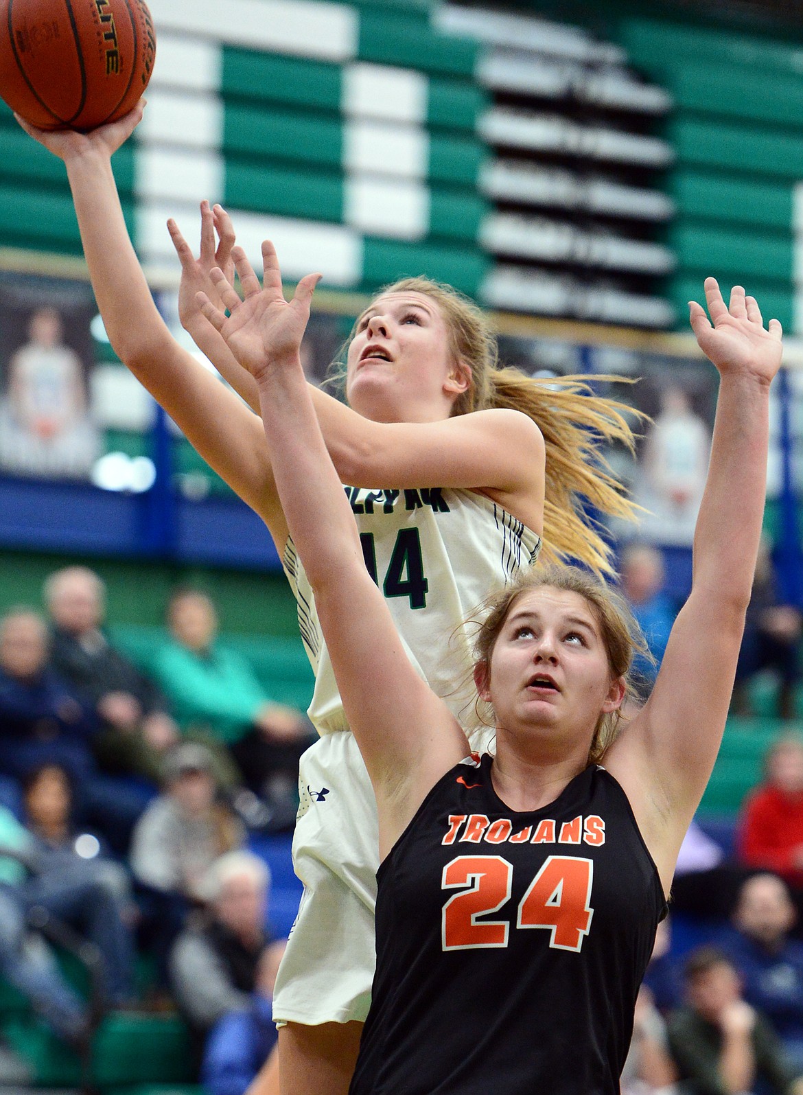 Glacier's Aubrie Rademacher (14) drives to the basket over Post Falls' Sandy Faulkner (24) at Glacier High School on Friday. (Casey Kreider/Daily Inter Lake)