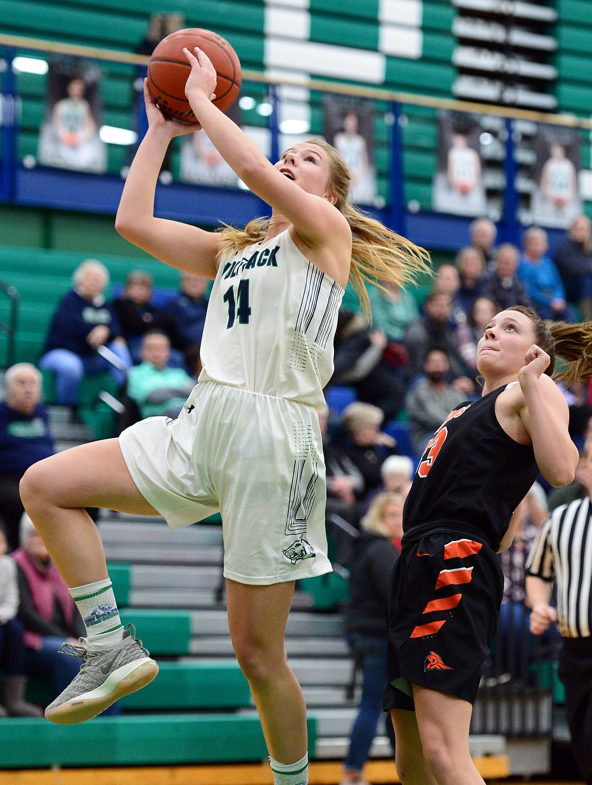 Glacier's Aubrie Rademacher (14) drives to the basket past Post Falls' Dylan Lovett (33) at Glacier High School on Friday. (Casey Kreider/Daily Inter Lake)