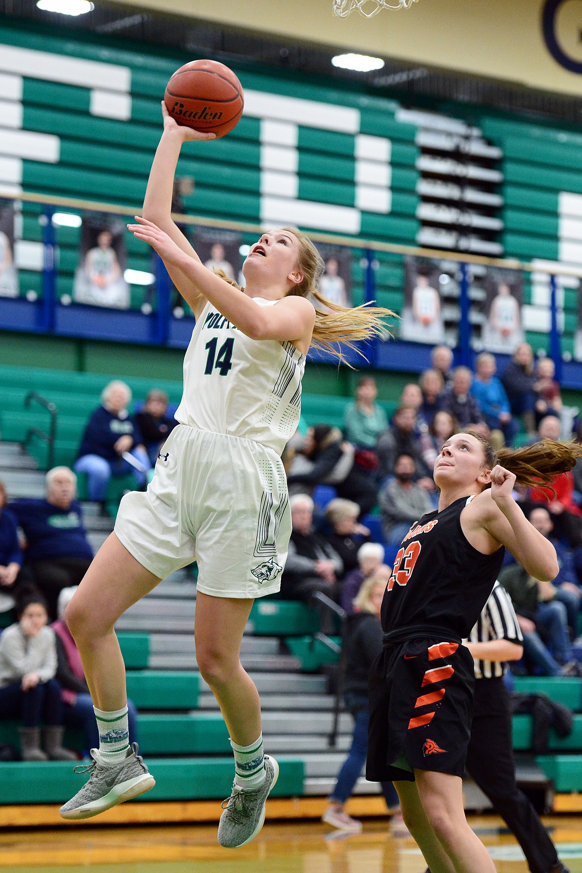 Glacier's Aubrie Rademacher (14) drives to the basket past Post Falls' Dylan Lovett (33) at Glacier High School on Friday. (Casey Kreider/Daily Inter Lake)