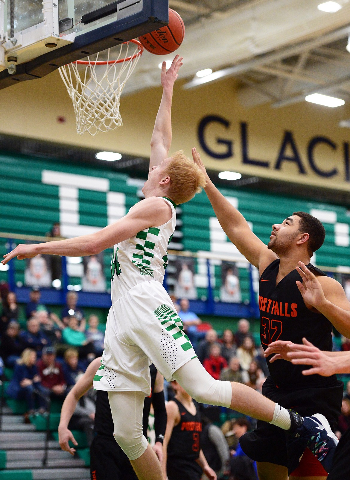 Glacier's Bret Michaels (34) drives to the basket past Post Falls' Terrell Mitchell at Glacier High School on Friday. (Casey Kreider/Daily Inter Lake)