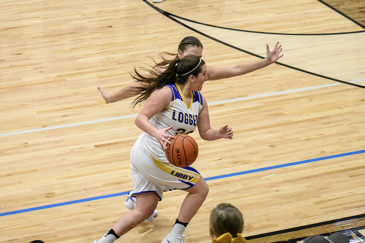 Libby senior Sammee Bradeen makes a break around Columbia Falls sophomore Lakia Hill as she prepares to pass to Libby senior McKenzie Proffitt early in the second quarter Friday. (Ben Kibbey/The Western News)