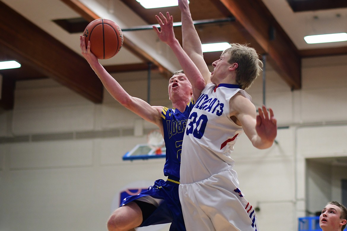 Libby&#146;s Ryggs Johnston takes the ball up against Wildcat Zach Pletcher for two of his game-high 27 points Thursday. (Jeremy Weber photo)