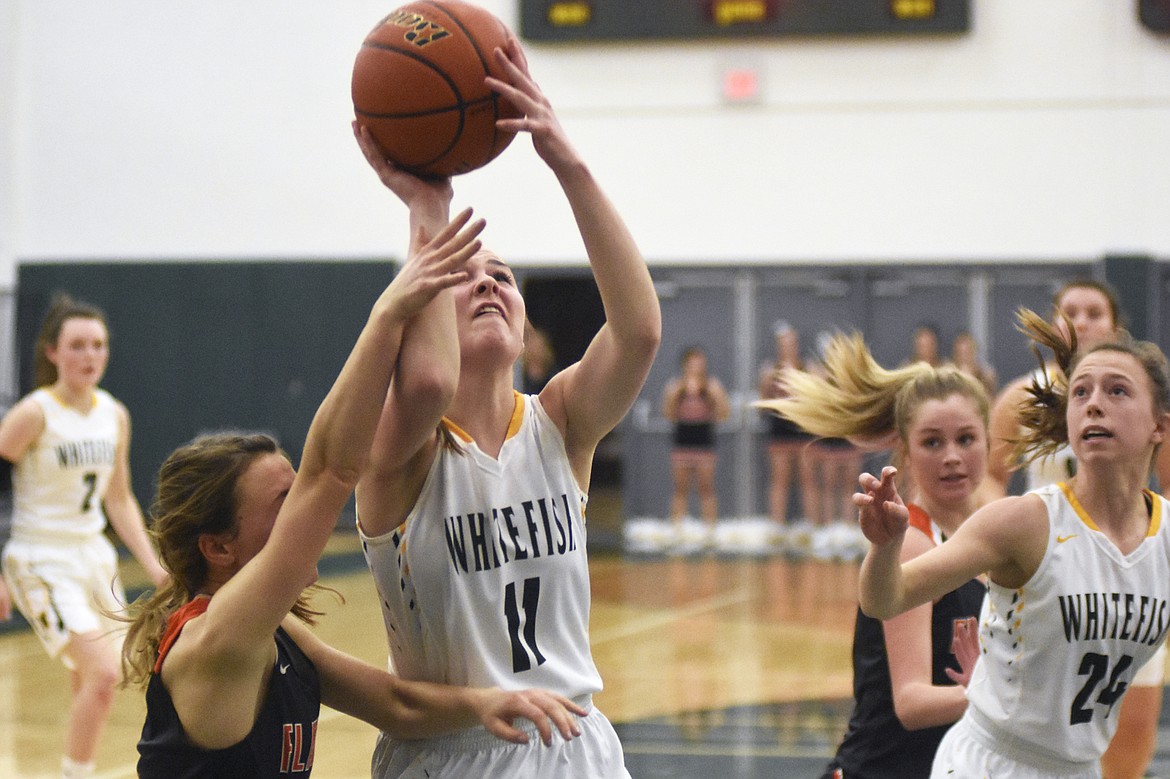 Claire Carloss fights for a layup during Friday's home loss to Flathead. (Daniel McKay/Whitefish Pilot)