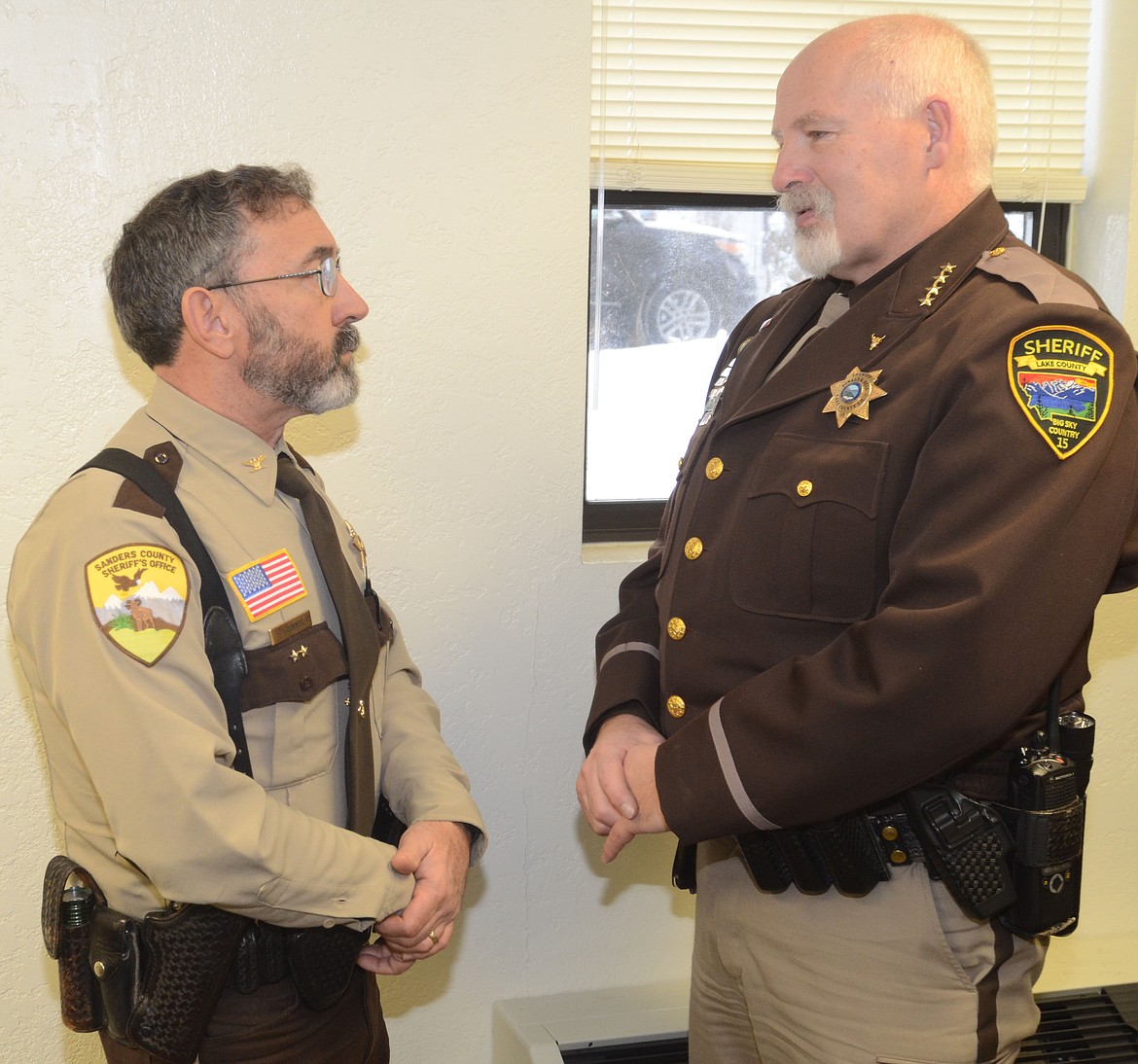 Sanders County Sheriff Tom Rummel, left, chats with Don Bell, the Lake County sheriff, after Rummel was sworn in for another term at a Dec. 27 ceremony at the courthouse in Thompson Falls. (Joe Sova/Clark Fork Valley Press)