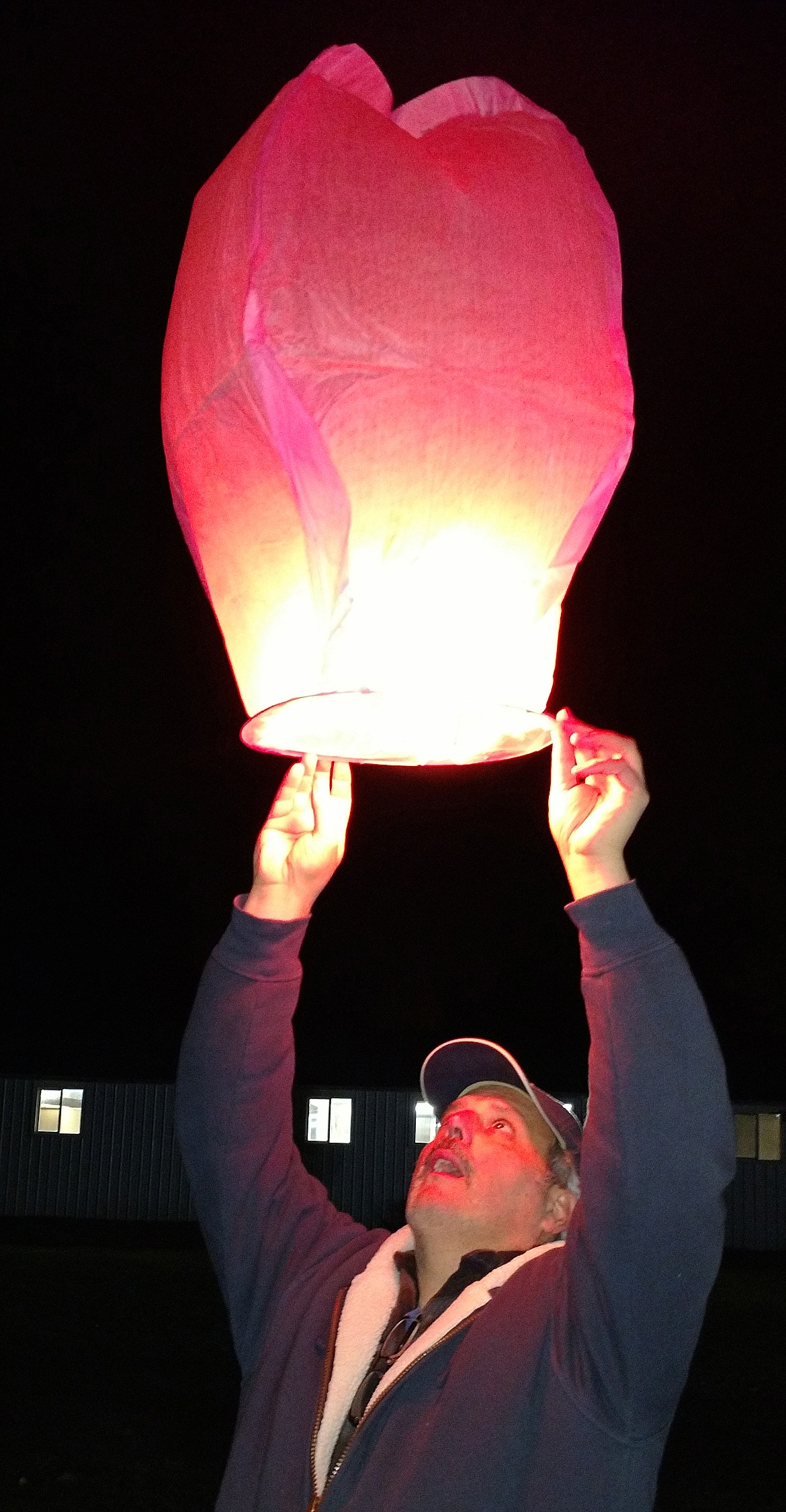 STEVE SEILHYMER carefully sends a luminary skyward during the Cancer Network of Sanders County Lantern Launch on Saturday, Oct. 20 outside the ag building at the Sanders County Fairgrounds. CNSC assists people afflicted with cancer who need help to get to medical appointments by providing funds for transportation or travel costs. (Joe Sova/Clark Fork Valley Press)