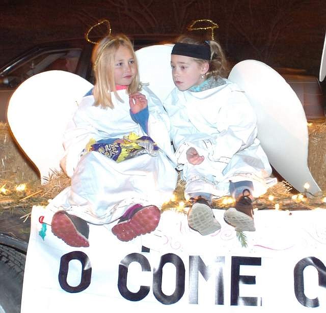 TWO ANGELS ride above the &quot;O Come All Ye Faithful&quot; signage on the St. Williams Catholic Church float during Thompson Falls Christmas On Main Street on the evening of Dec. 1. The celebration theme was &quot;Christmas in the Old West.&quot; (Joe Sova/Clark Fork Valley Press)