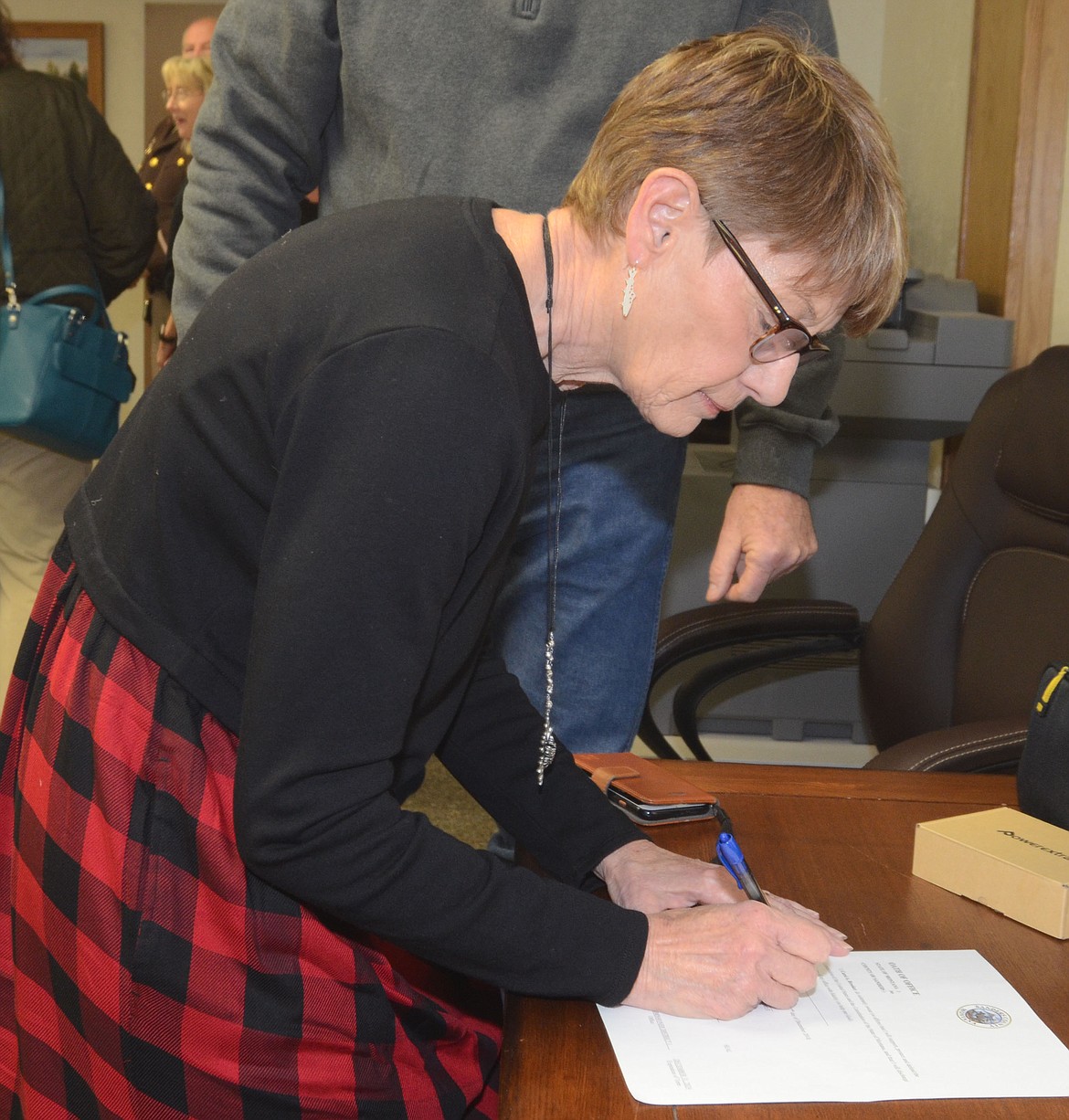 Sanders County Commissioner Carol Brooker, who was re-elected in the November 2018 General Election, signs the official form after taking her oath during the Dec. 27 ceremony at the Sanders County Courthouse.