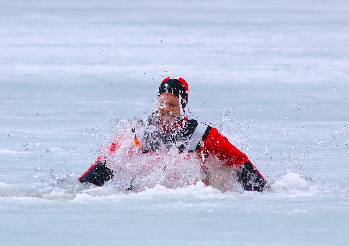 Photo by MANDI BATEMANHall Mountain Firefighter Ben Allinger breaks through the ice on Robinson Lake during ice rescue training on April 14.