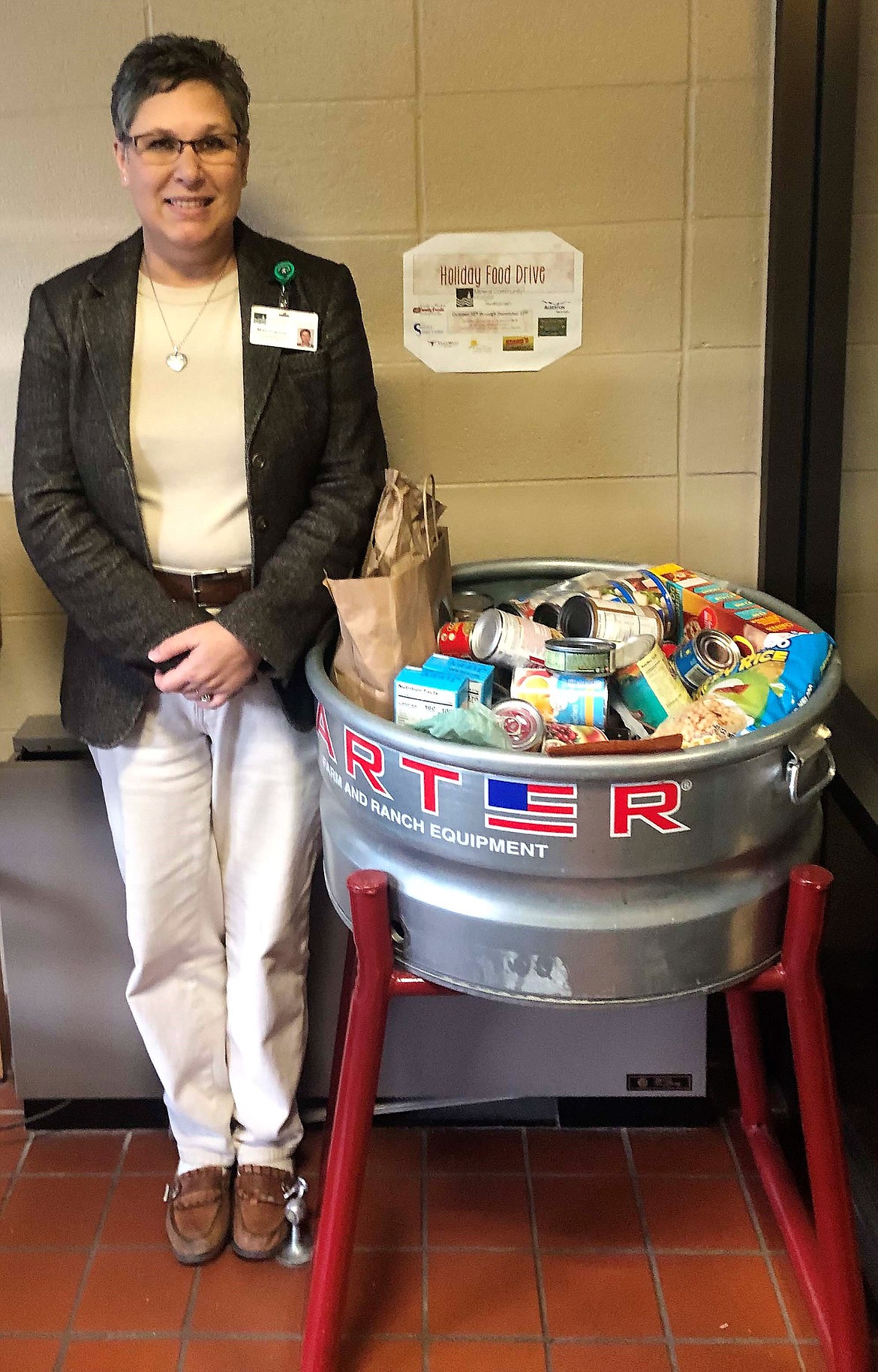 Mitzi Francis, executive assistant at the Mineral Community Hospital, helped receive Mineral County Food Bank donations from the Shining Mountains Chapter of the Montana Wilderness Association in December. (Photo courtesy of MT Wilderness Association)