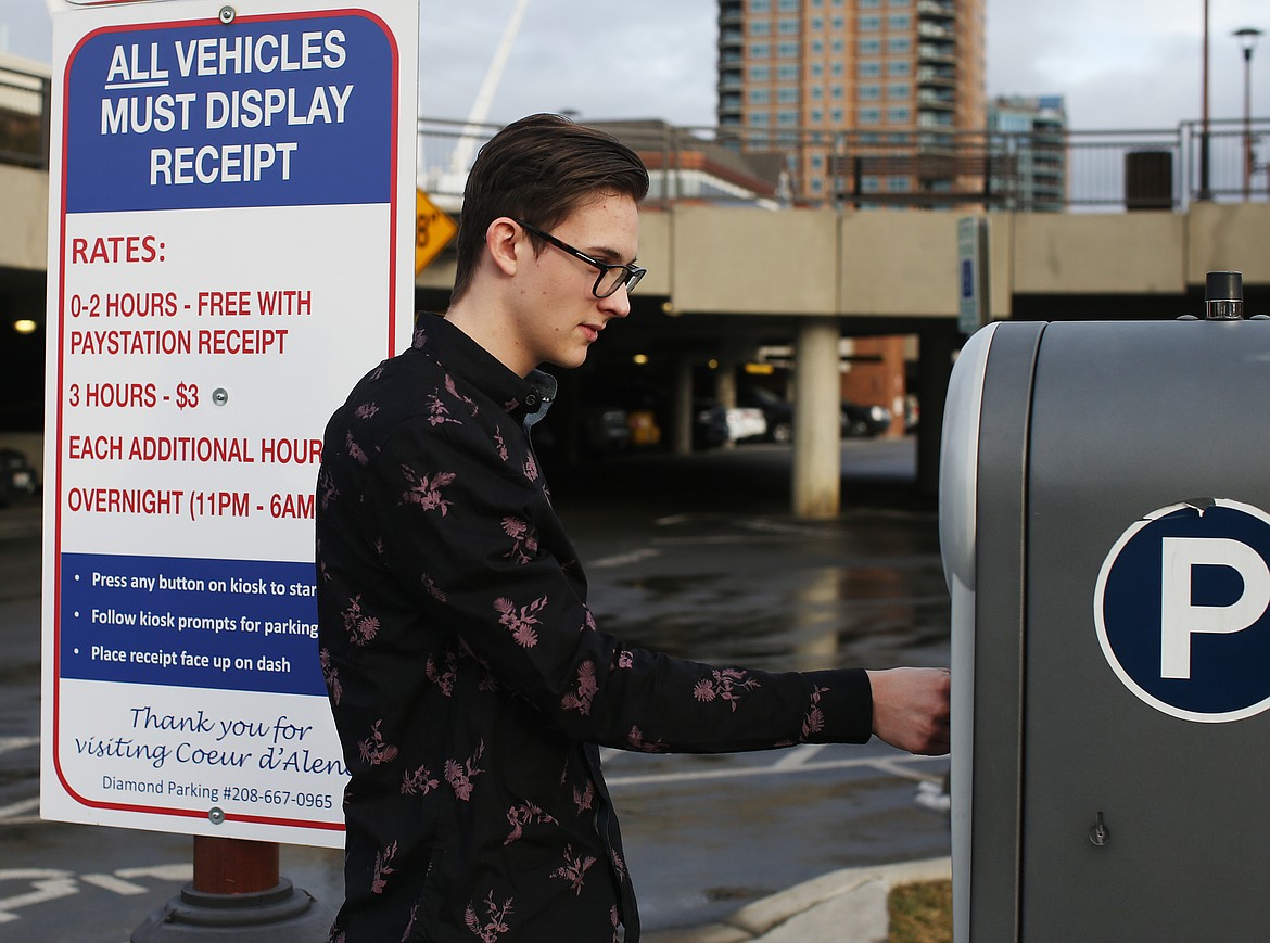 Ashton Williams uses an automated parking kiosk after parking at the lot at McEuen Park Friday in Coeur d&#146;Alene. (LOREN BENOIT/Press)