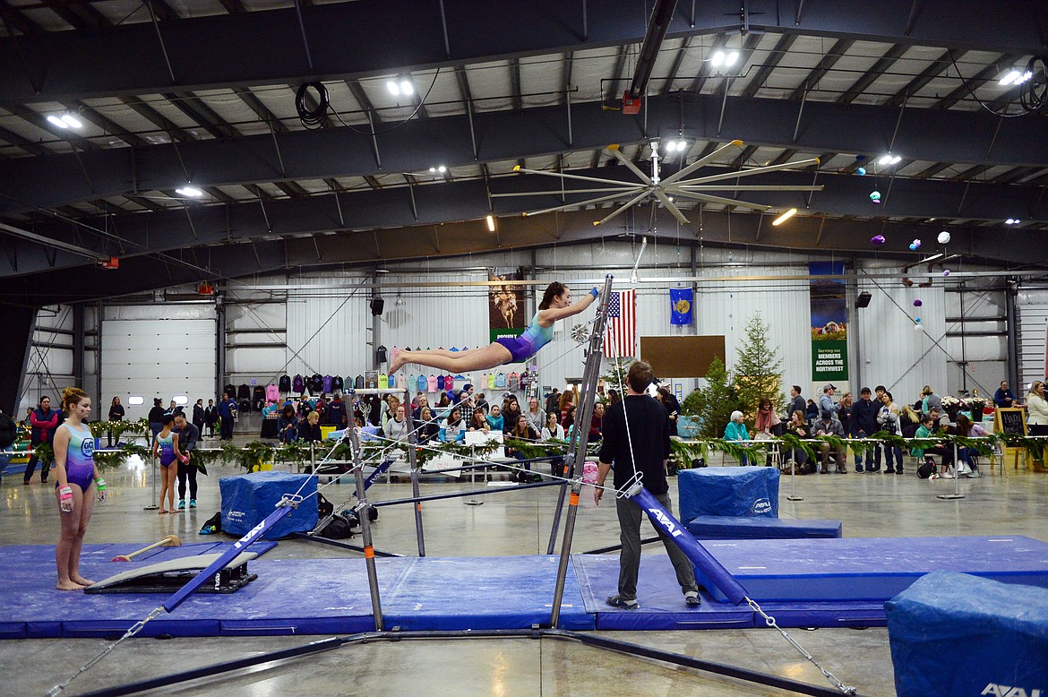 Nora Iams, from Flathead Gymnastics Academy, warms up on the uneven bars at the 4th annual Glacier Challenge at the Flathead County Fairgrounds Trade Center in Kalispell on Saturday. (Casey Kreider/Daily Inter Lake)