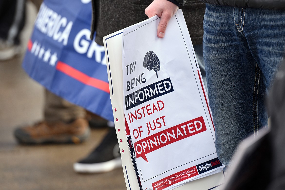 Attendees hold signs during a rally in support of President Donald Trump along East Center Street in Kalispell on Saturday. (Casey Kreider/Daily Inter Lake)