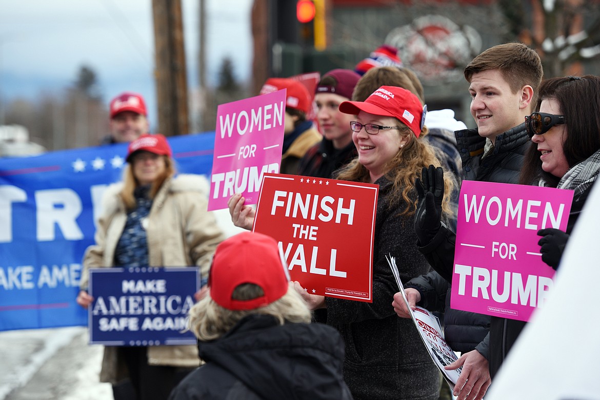 Attendees hold signs during a rally in support of President Donald Trump along East Center Street in Kalispell on Saturday.