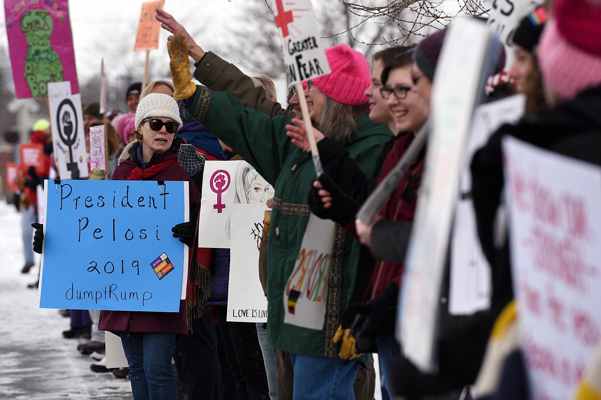 Attendees of the Kalispell Women's March hold signs along North Main Street outside Depot Park on Saturday. (Casey Kreider/Daily Inter Lake)