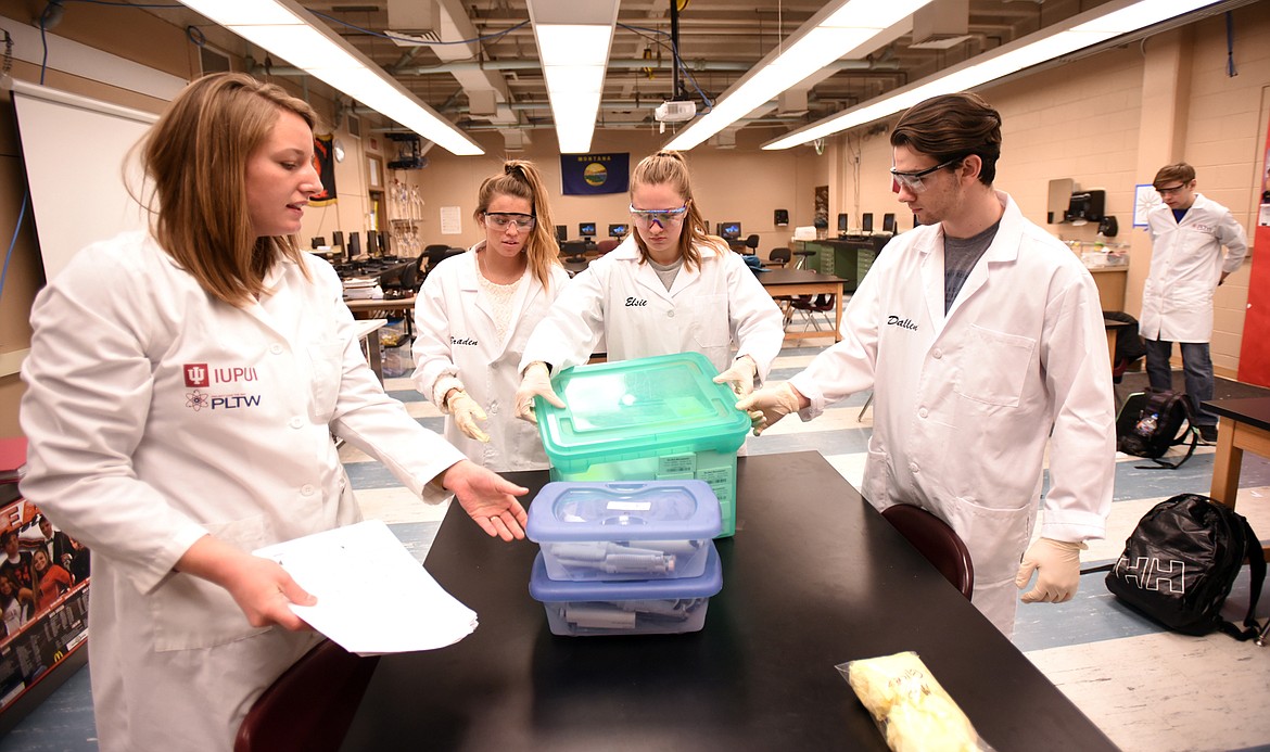 Linzi Napier gives instructions to students Hailey Gardner, left to right, Elsie Sarkkinen, Collin Dallen and Derrick Neater is in the background, as they start their work in the Biomedical Science Lab at Flathead High School.
(Brenda Ahearn/Daily Inter Lake)