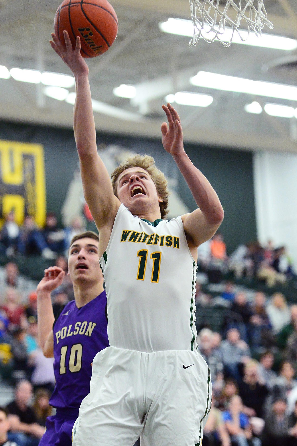 Whitefish's Mark Anderson (11) heads to the hoop in front of Polson's Ryker Wenderoth (10) at Whitefish High School on Friday. (Casey Kreider/Daily Inter Lake)