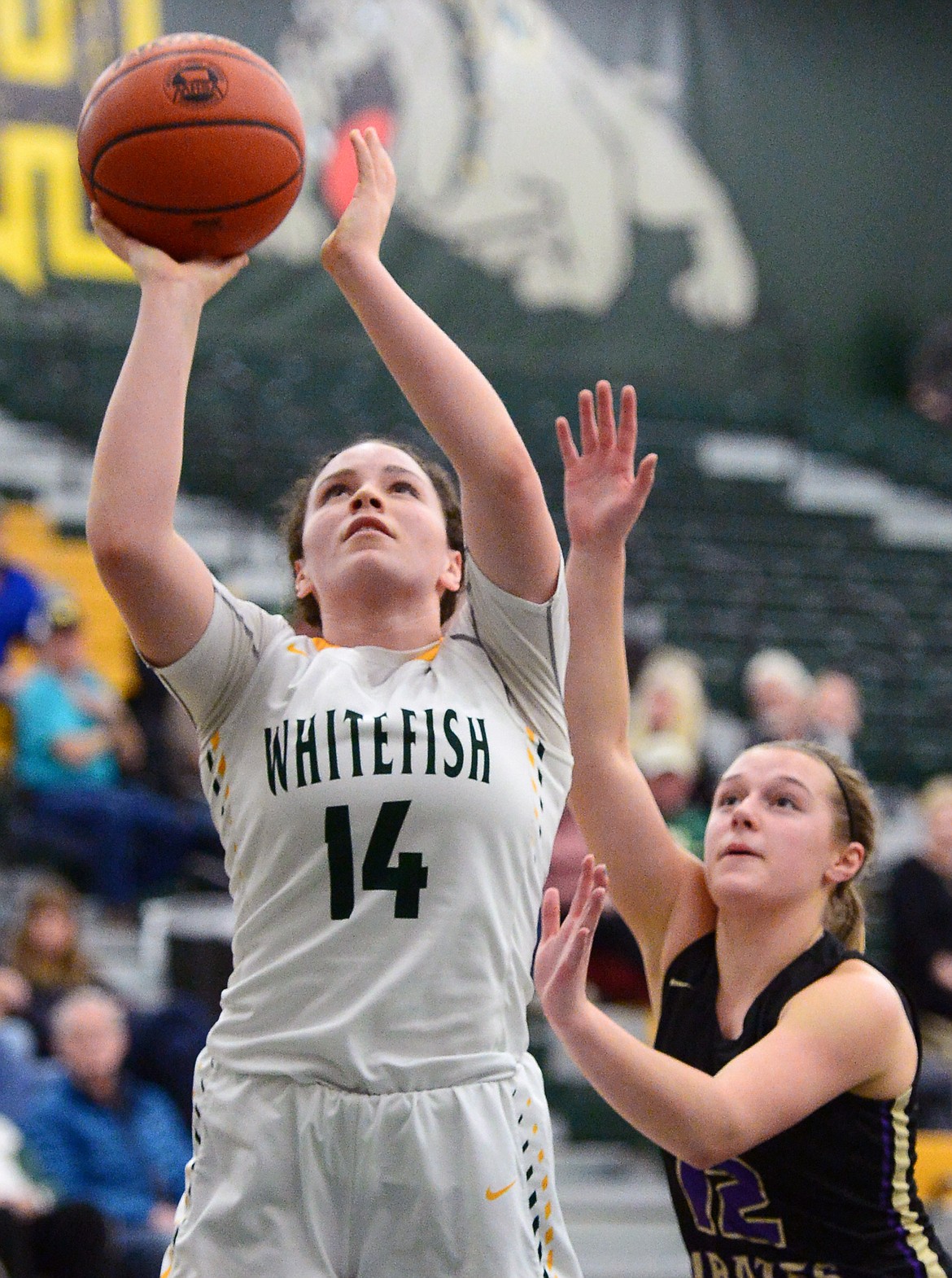 Whitefish's Gracie Smyley (14) goes to the hoop in front of Polson's Shayla Olson (12) at Whitefish High School on Friday. (Casey Kreider/Daily Inter Lake)