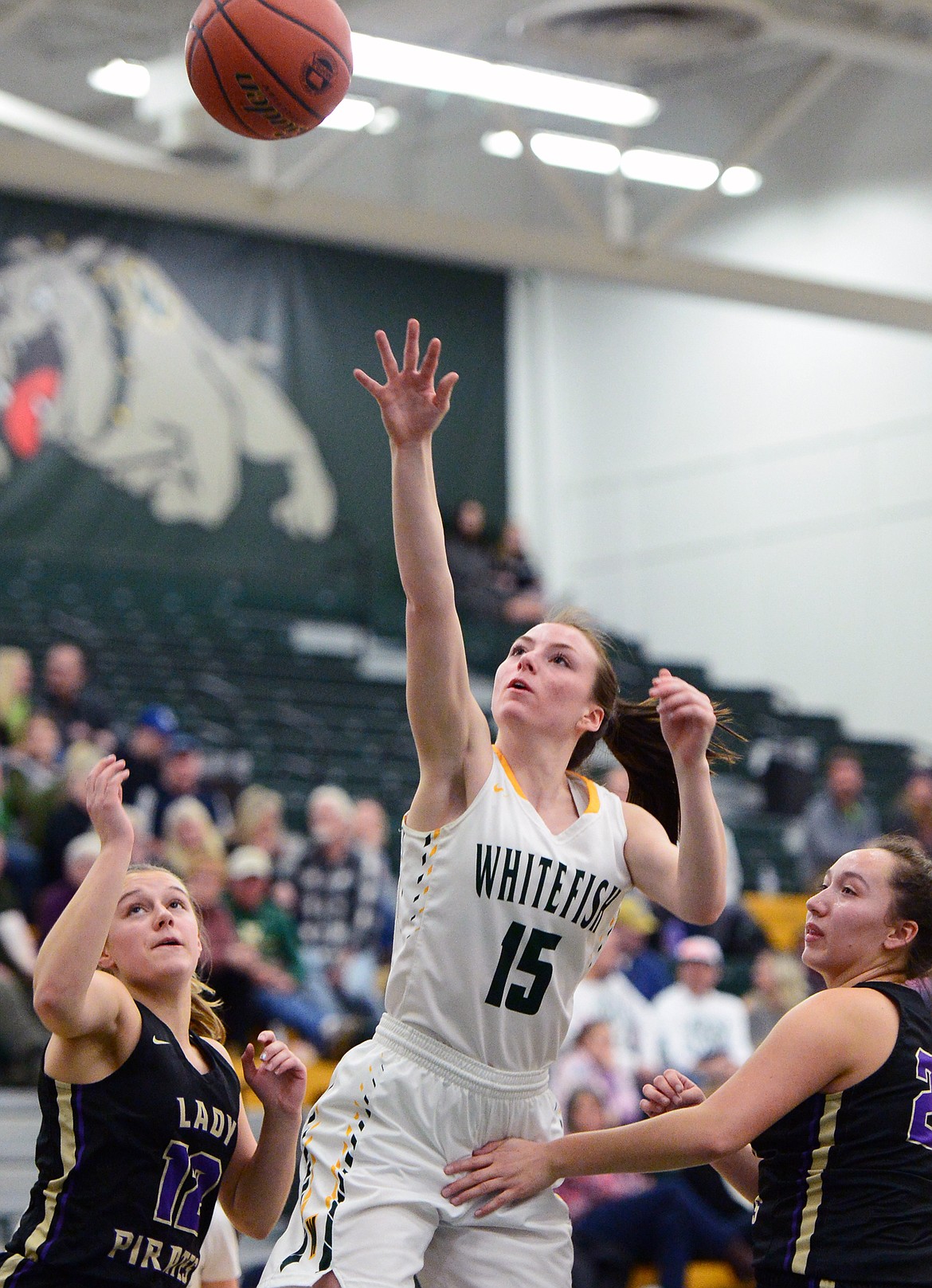 Whitefish's Payton Kastella (15) shoots between Polson's Shayla Olson (12) and Misty Tenas (24) at Whitefish High School on Friday. (Casey Kreider/Daily Inter Lake)