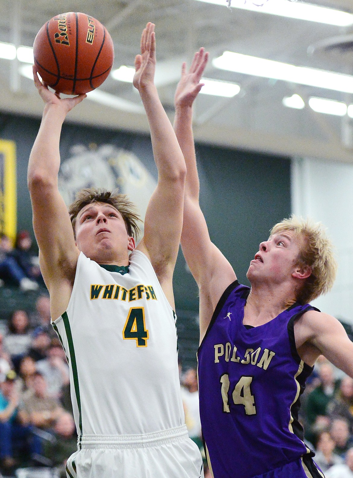 Whitefish's Jack Schwaiger (4) heads to the basket with Polson's Trevor Schultz (14) defending at Whitefish High School on Friday. (Casey Kreider/Daily Inter Lake)