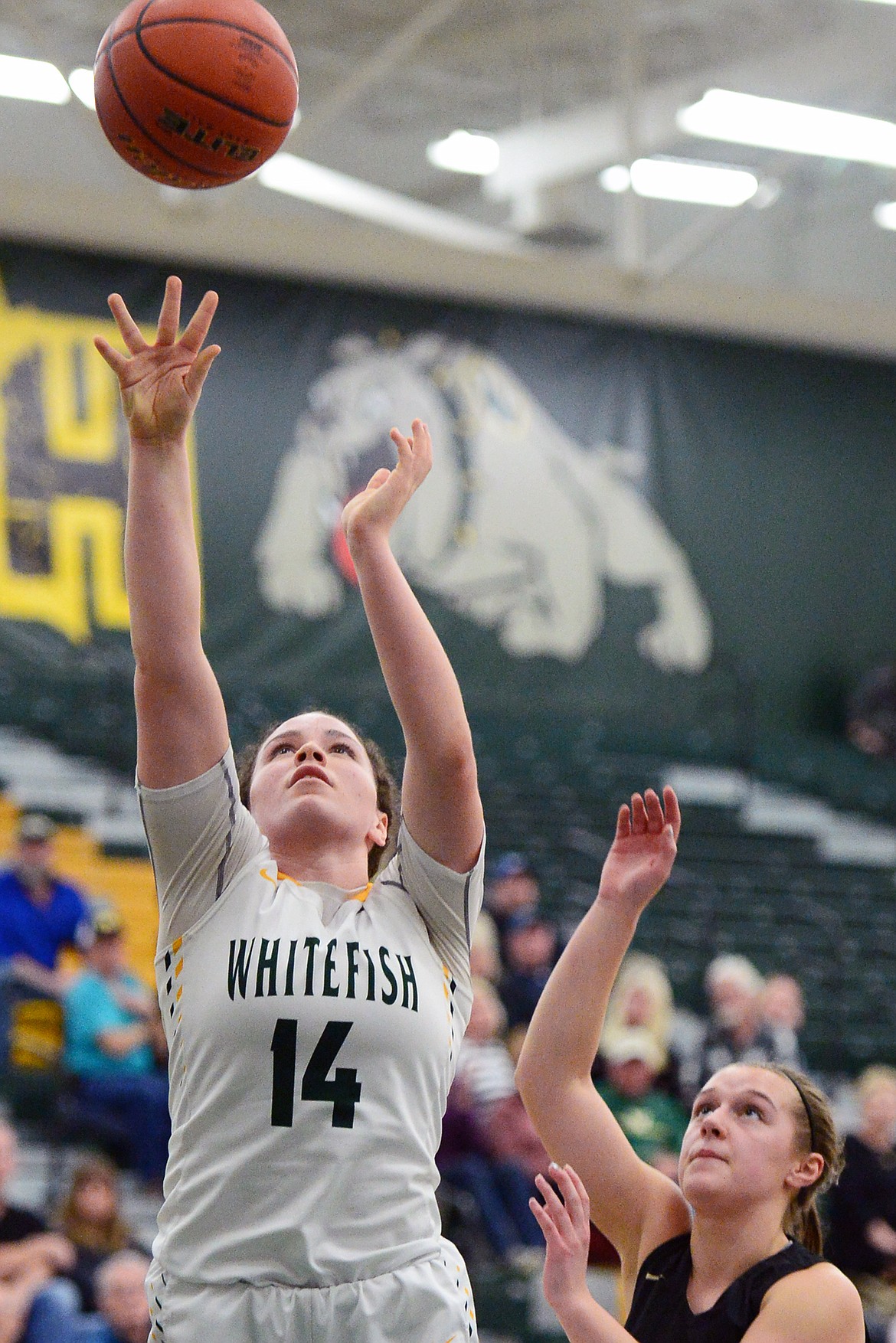 Whitefish's Gracie Smyley (14) goes to the hoop in front of Polson's Shayla Olson (12) at Whitefish High School on Friday. (Casey Kreider/Daily Inter Lake)