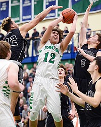 Glacier's Weston Price (12) powers to the rim between Flathead's Anthony Jones (42) and Tannen Beyl (5) during a crosstown matchup at Glacier High School on Friday. Beyl was whistled for a foul on the play. (Casey Kreider/Daily Inter Lake)