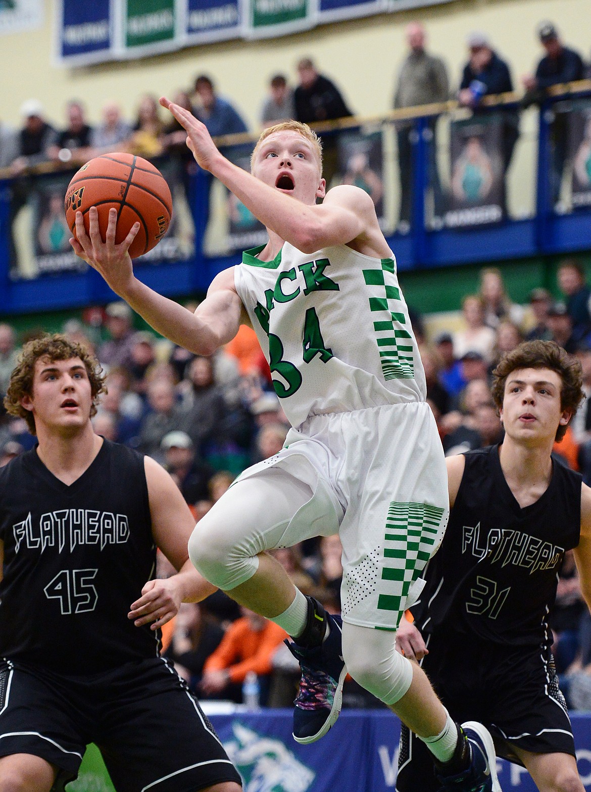 Glacier's Bret Michaels (34) drives to the rim past Flathead defenders Andrew Siderius (45) and Brett Thompson (31) during a crosstown matchup at Glacier High School on Friday. (Casey Kreider/Daily Inter Lake)