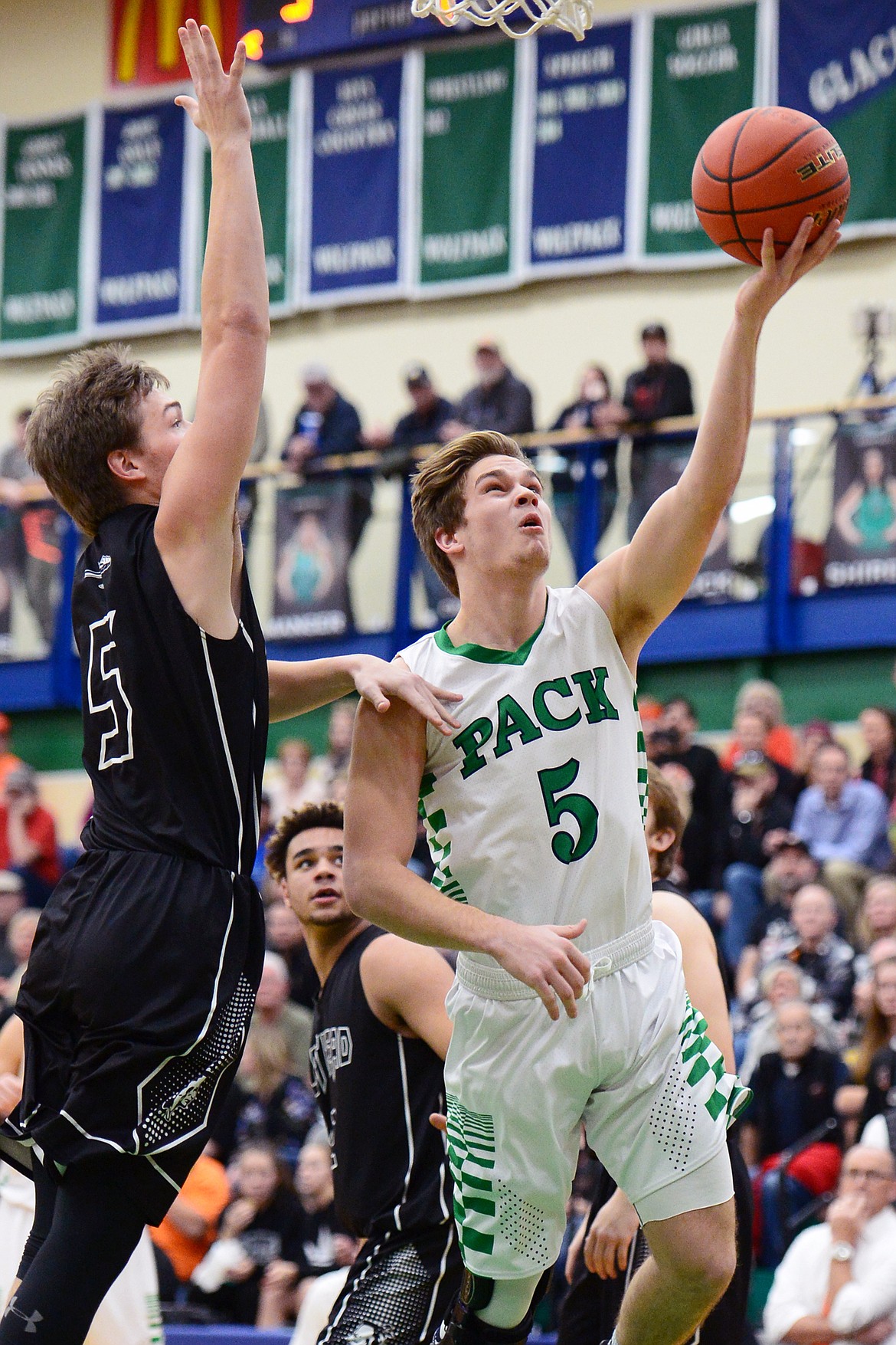 Glacier's Ethan Baines (5) drives to the hoop with Flathead's Tannen Beyl (5) defending during a crosstown matchup at Glacier High School on Friday. (Casey Kreider/Daily Inter Lake)