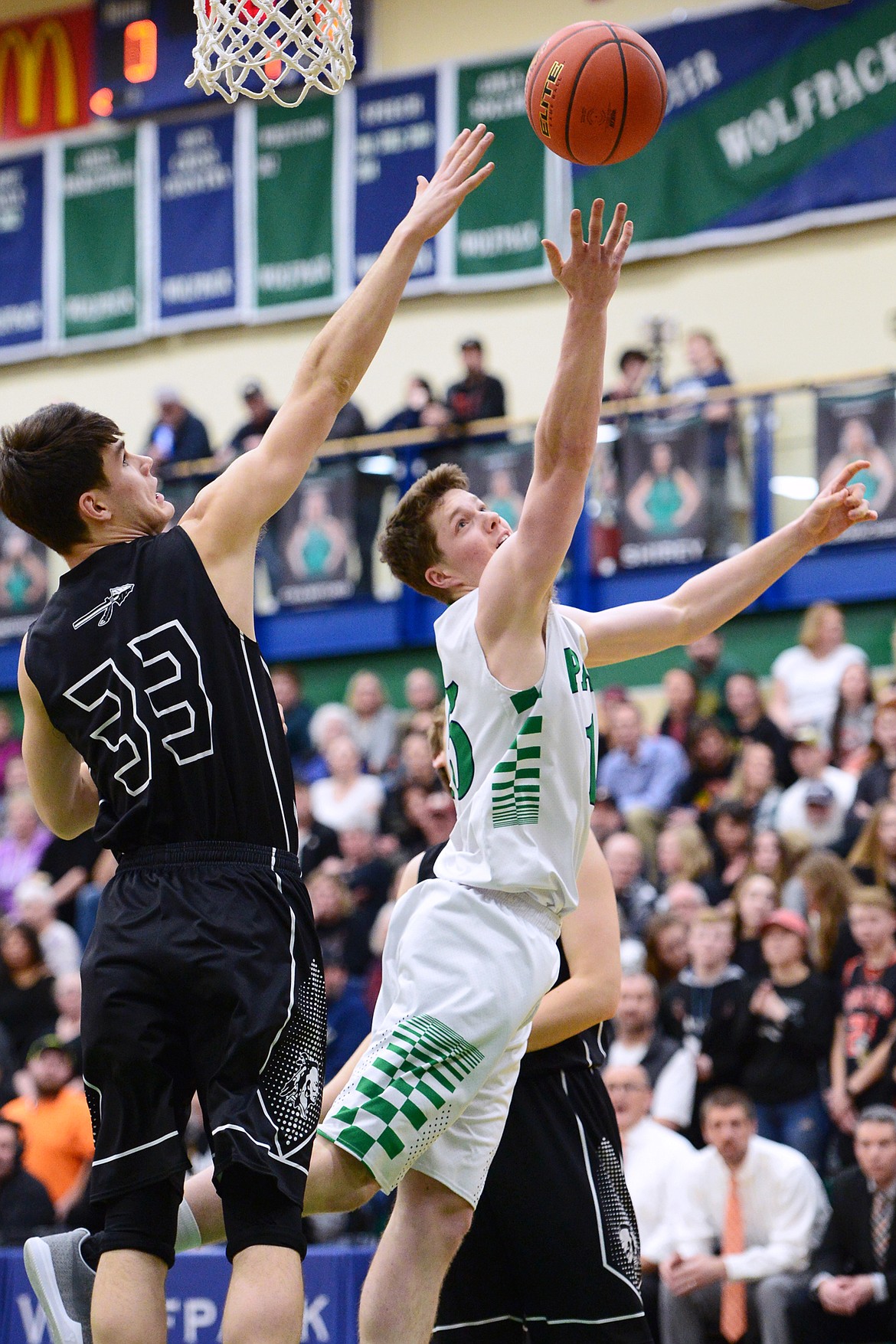 Glacier's Drew Engellant (15) drives to the basket with Flathead's Gabe Adams (33) defending during a crosstown matchup at Glacier High School on Friday. (Casey Kreider/Daily Inter Lake)