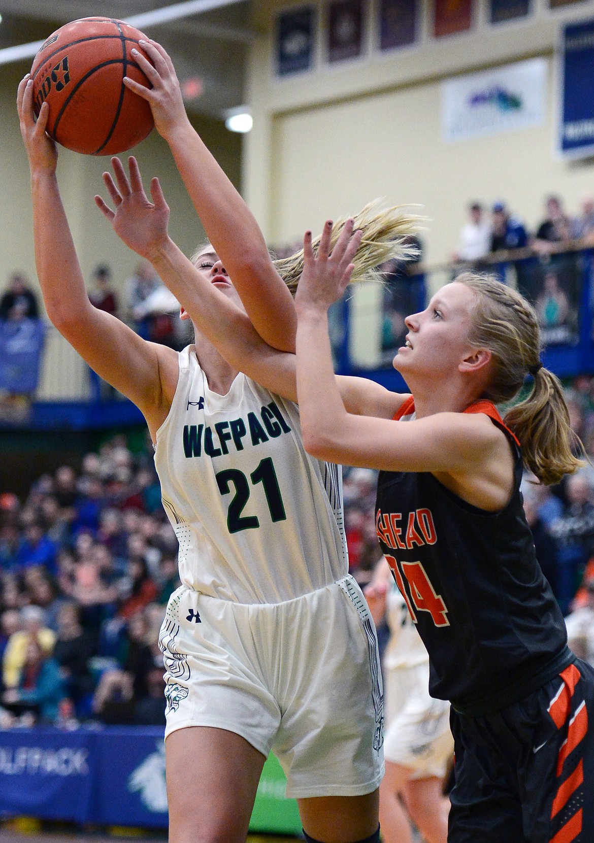 Glacier's Abi Manger (21) and Flathead's Jenna Johnson (14) battle for a rebound during a crosstown matchup at Glacier High School on Friday. (Casey Kreider/Daily Inter Lake)