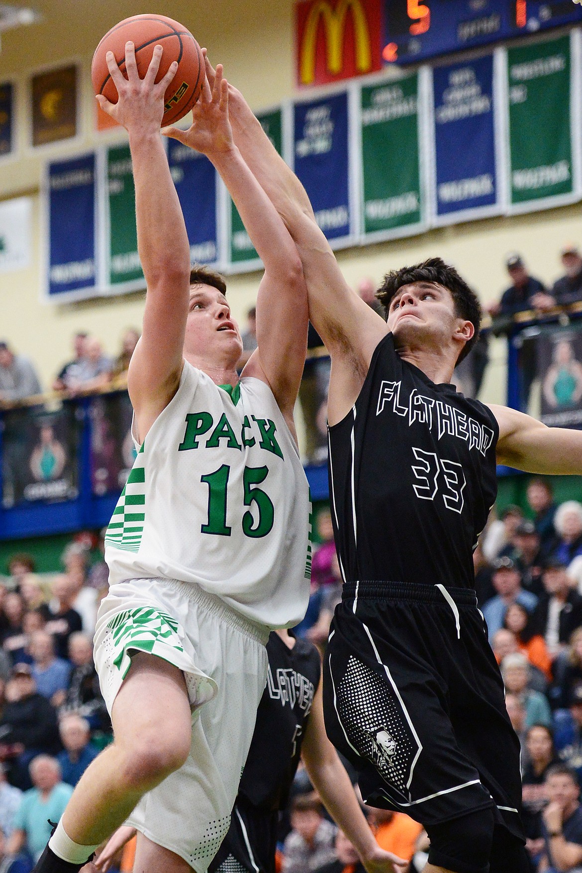 Glacier's Drew Engellant (15) drives to the hoop with Flathead's Gabe Adams (33) defending during a crosstown matchup at Glacier High School on Friday. (Casey Kreider/Daily Inter Lake)