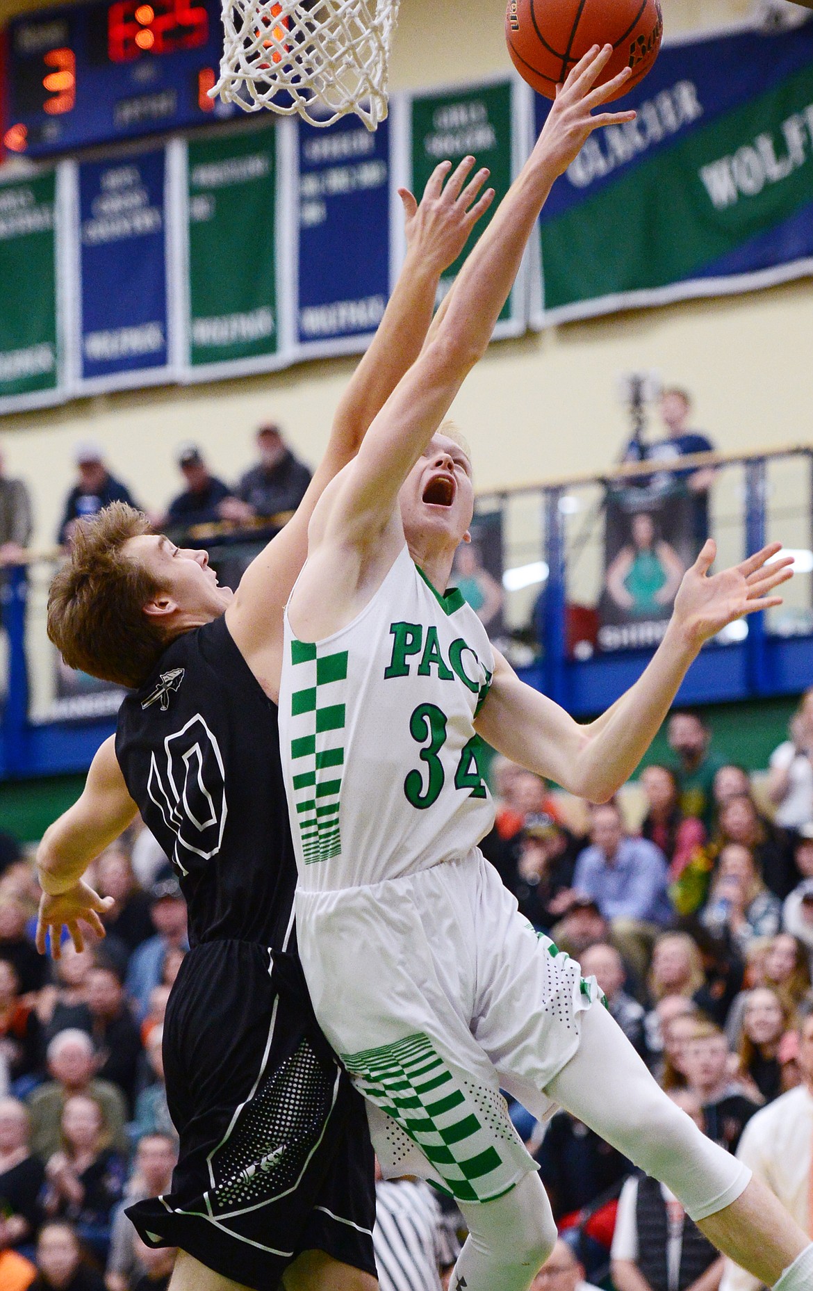 Glacier's Bret Michaels (34) drives to the hoop with Flathead's Stephen Bridges (10) defending during a crosstown matchup at Glacier High School on Friday. (Casey Kreider/Daily Inter Lake)