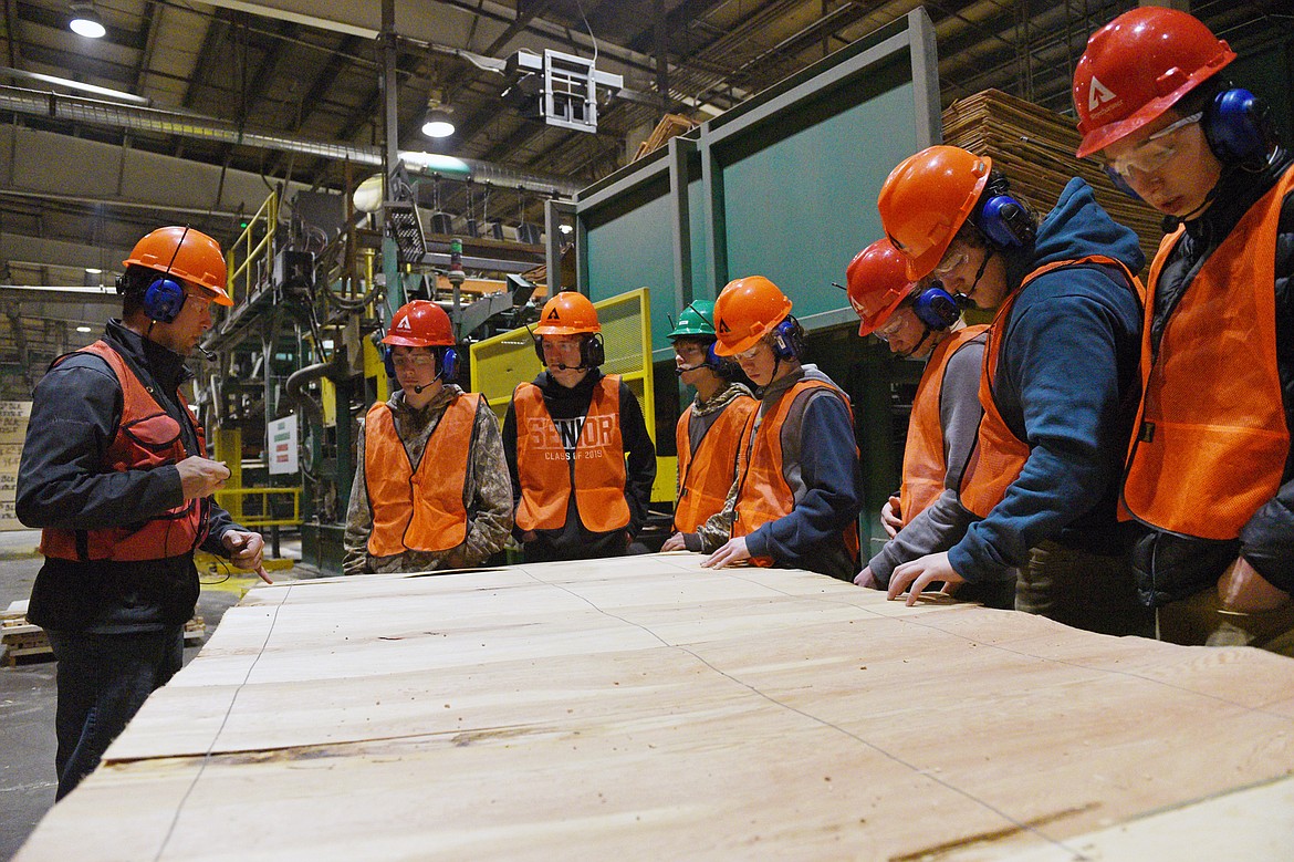 Travis Owen, left, a production scheduler at Weyerhaeuser, leads a group of Flathead High School students on a tour of their Evergreen facility on Wednesday, Jan. 9. (Casey Kreider/Daily Inter Lake)