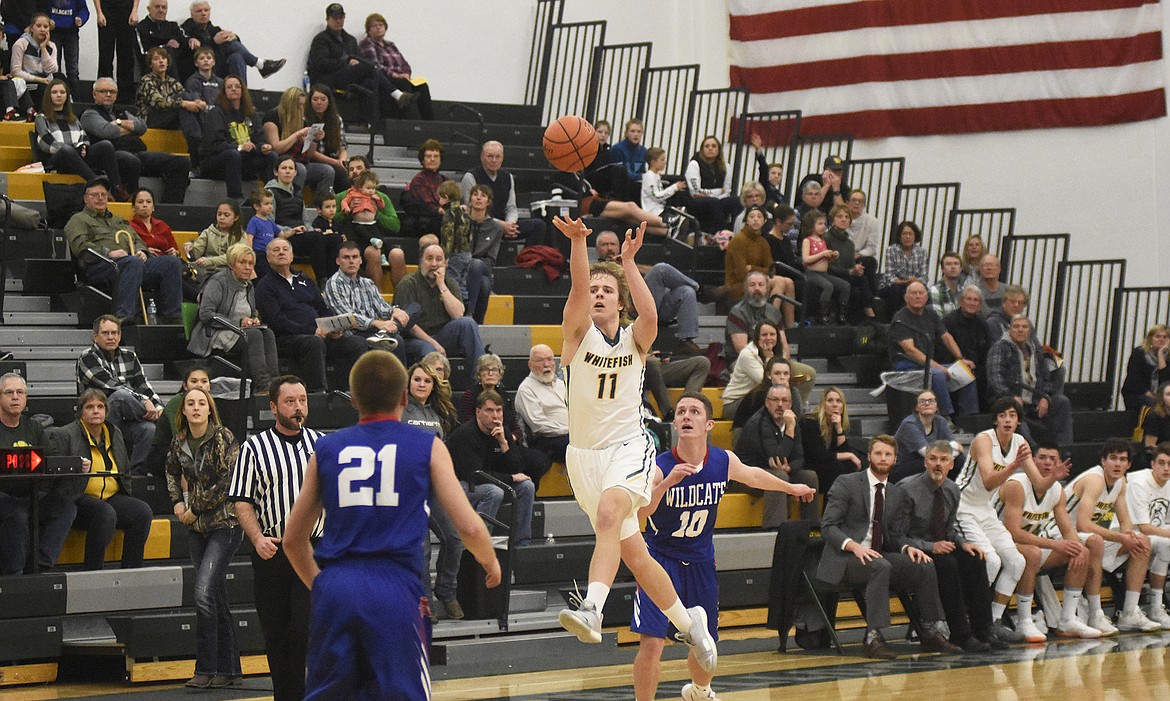 Mark Anderson launches a successful half-court heave to end the first half during the Dogs&#146; 60-45 rivalry win on Thursday. (Daniel McKay/Whitefish Pilot)