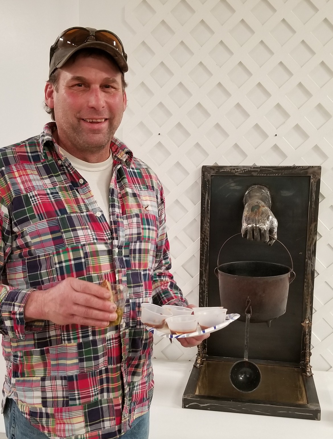 Photo by MANDI BATEMAN
Artist Mike Krejci, in front of the trophy he created, and holding a plate full of chili samples.