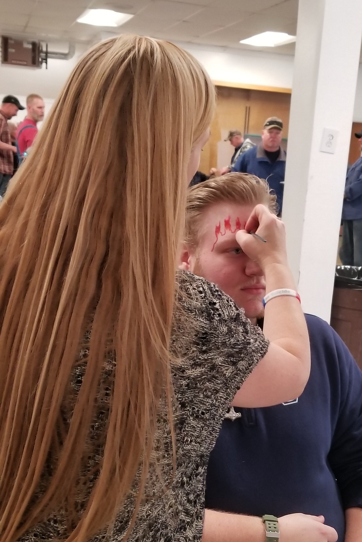 Photo by MANDI BATEMAN
North Bench Firefighter Keanen Hurst gets flames painted on his face.