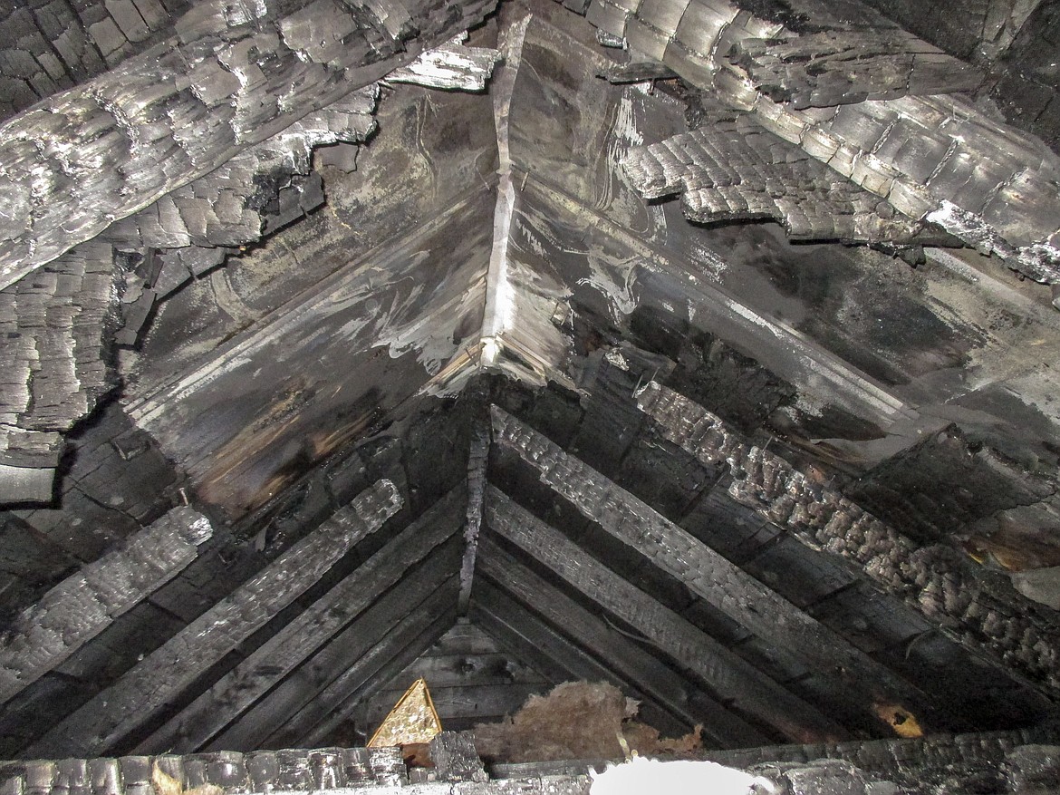 The fire that almost claimed the Grizzly Ranch homestead cabin completely consumed structural timbers in the attic, and smoke was rolling and billowing out fast from under the eaves when the Upper Yaak VFD arrived on scene only 18 minutes after the first 911 call was received. (Photo courtesy Mike Sanders)