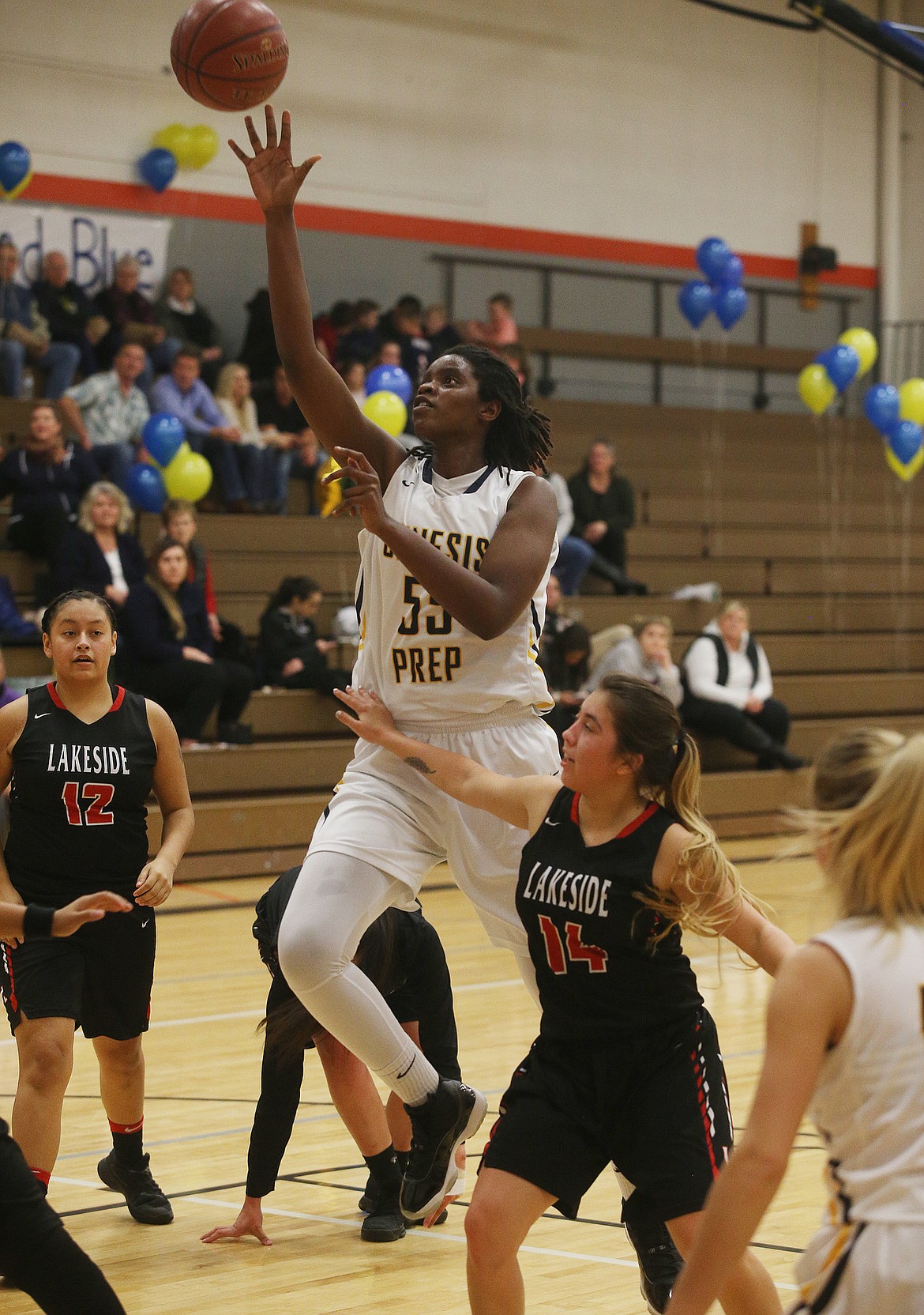 Genesis Prep senior center Bella Murekatete goes for a layup as Suzzana Pakootas (12) and Alyssa SiJohn (14) of Lakeside look on Friday night at Post Falls Middle School.