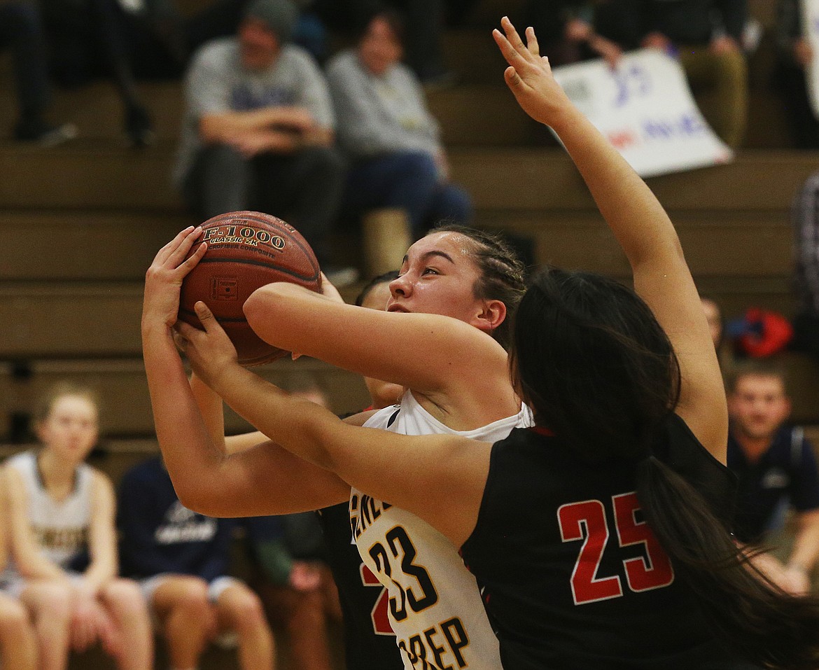 Genesis Prep senior forward Emily Martinez gathers the rebound as Kyra Peters (25) of Lakeside challenges during the second half of Friday night&#146;s game at Post Falls Middle School. (LOREN BENOIT/Press)