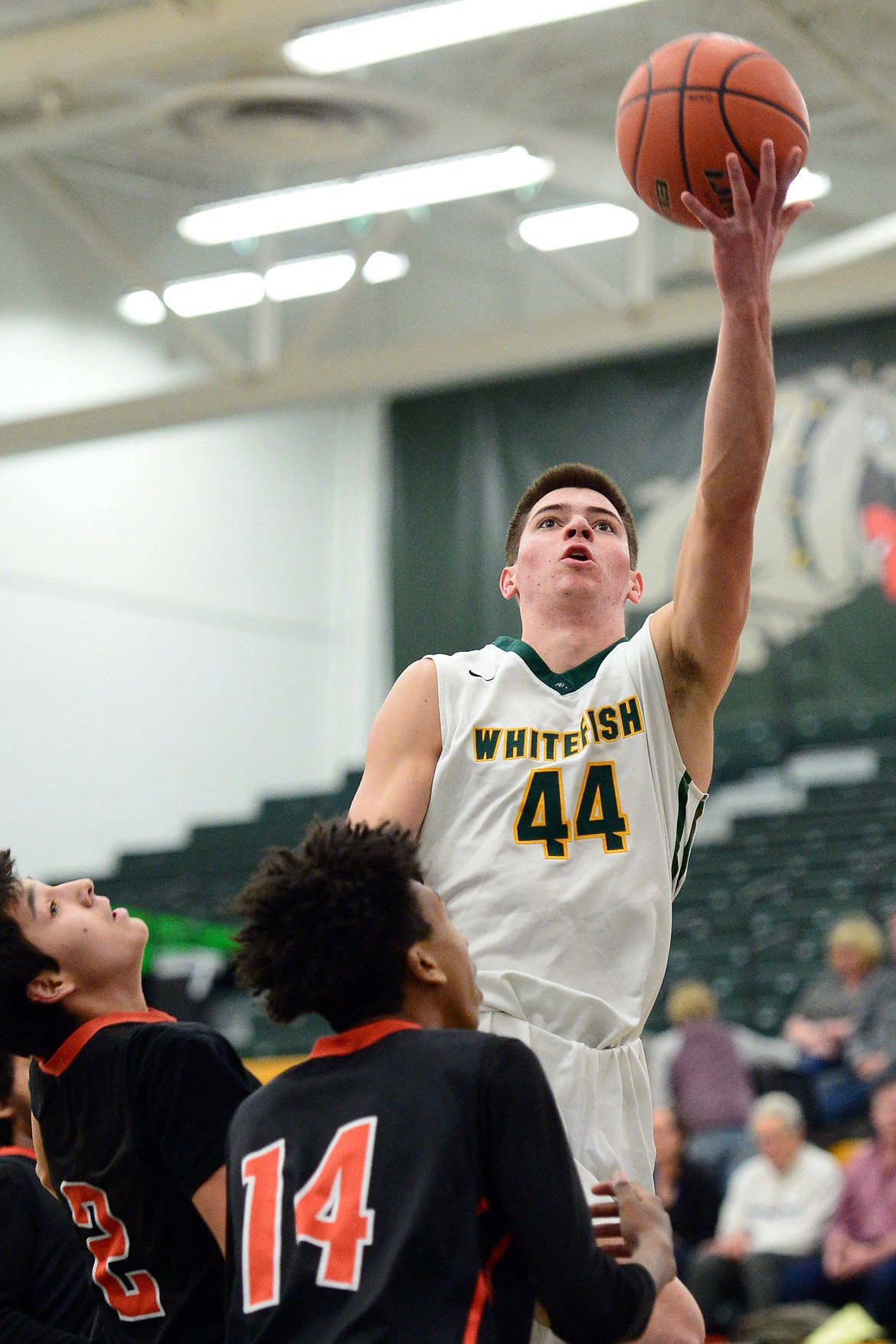 Whitefish's Lee Walburn (44) drives to the basket against Ronan defenders Terrell Stump (2) and Girma Detwiler (14) at Whitefish High School on Tuesday. (Casey Kreider/Daily Inter Lake)