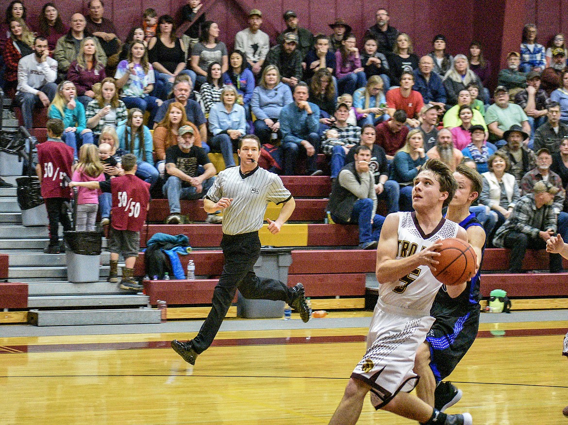 Troy junior Ricki Fisher drives to the basket late in the second quarter against Stillwater against Stillwater Saturday. (Ben Kibbey/The Western News)