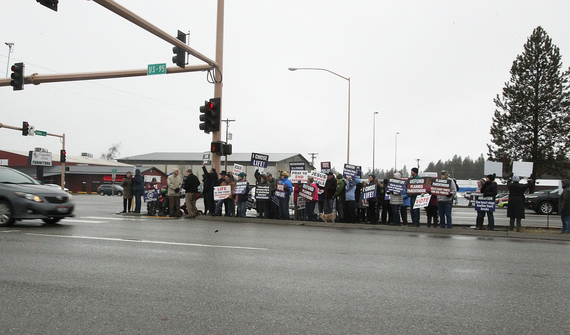 More than 100 people braved the rain Saturday morning as they participated in the 39th annual Right to Life Coeur d'Alene March and Rally. They held pro-life signs and waved to drivers as they waited to cross Highway 95 on Dalton Avenue. (DEVIN WEEKS/Press)