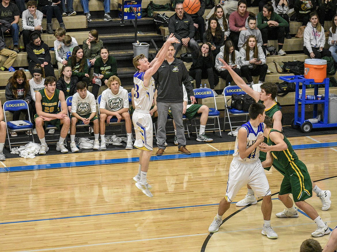 Libby senior Ryggs Johnston shoots for three, taking the lead for the Loggers, 15-11, early in the second quarter against Whitefish Saturday. (Ben Kibbey/The Western News)