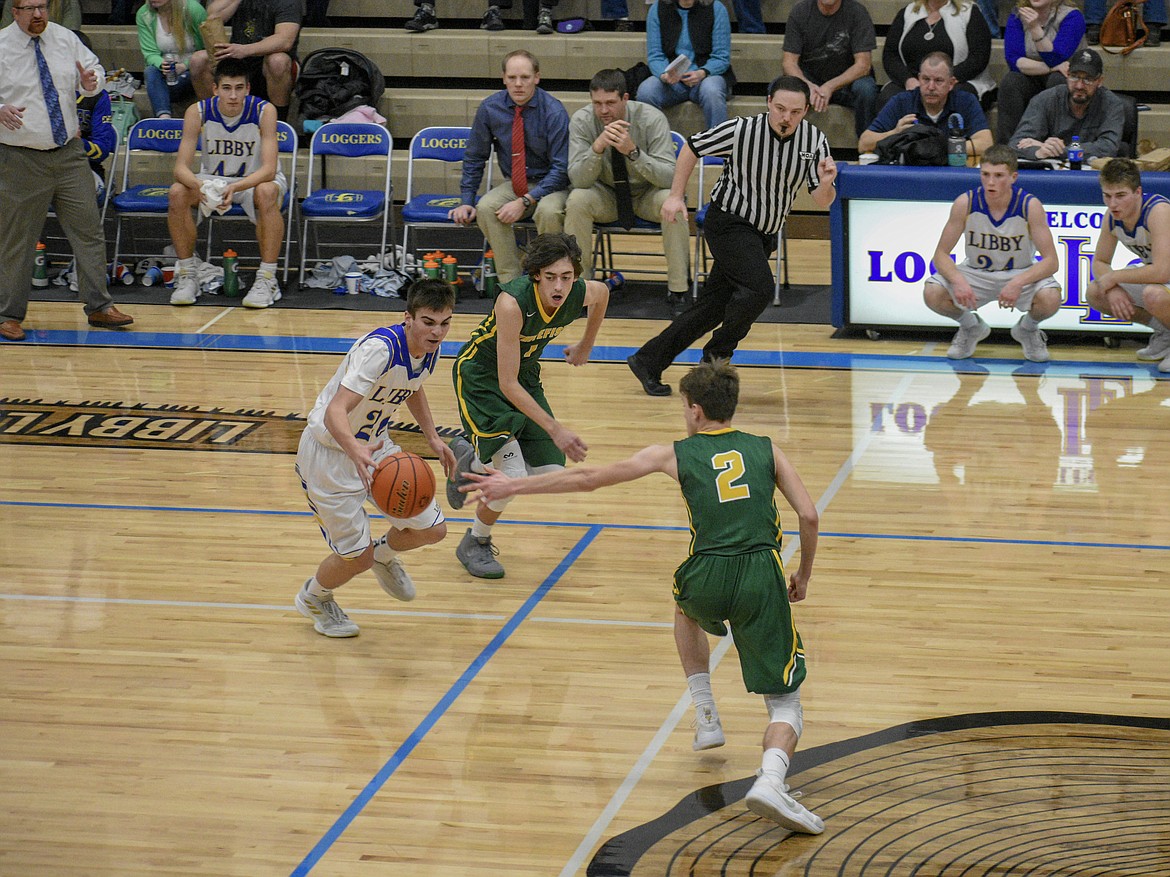 Libby junior Ryan Goodman steals a pass from the Whitefish offense before streaking down court for a layup late in the first half Saturday. (Ben Kibbey/The Western News)