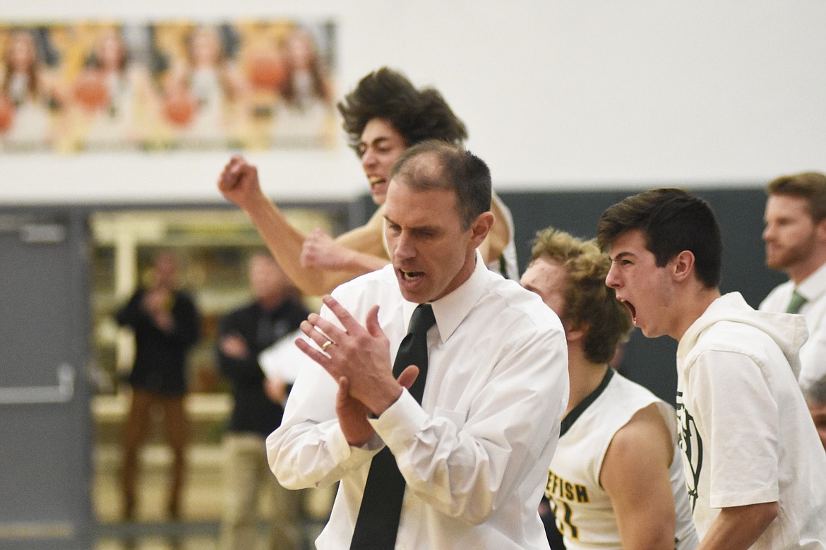 Whitefish head coach Scott Smith and his players celebrate during the Dogs' home win over Polson on Friday. (Daniel McKay/Whitefish Pilot)